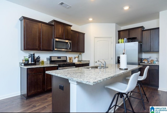 kitchen featuring appliances with stainless steel finishes, sink, dark hardwood / wood-style flooring, and a kitchen island with sink