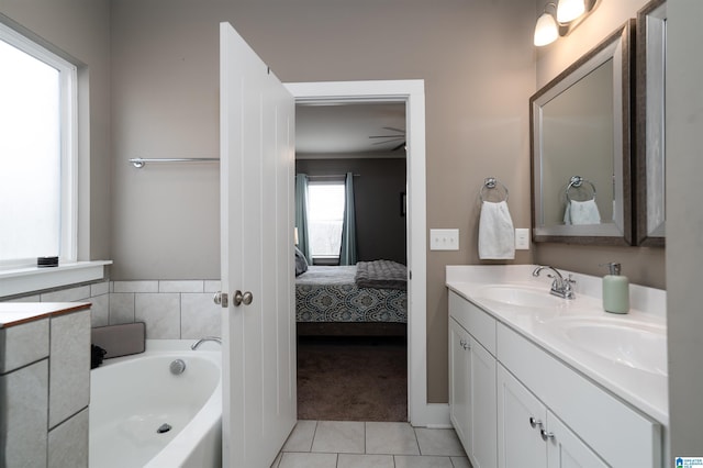 bathroom with a tub, tile patterned flooring, and vanity