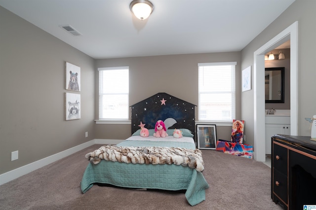 carpeted bedroom with sink and connected bathroom