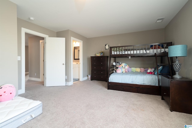 bedroom featuring light carpet and ensuite bath