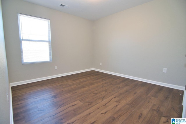 empty room with dark hardwood / wood-style flooring