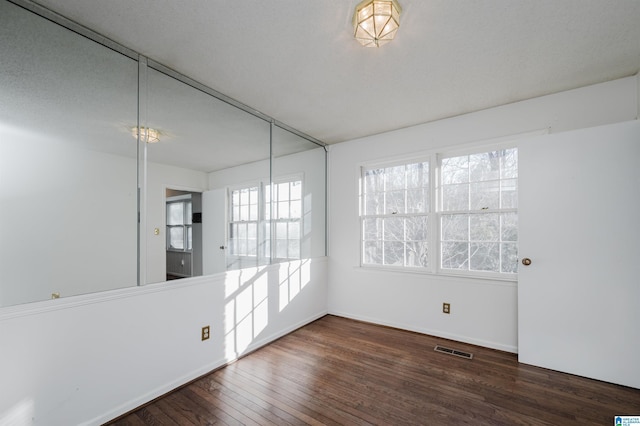 empty room with dark hardwood / wood-style flooring