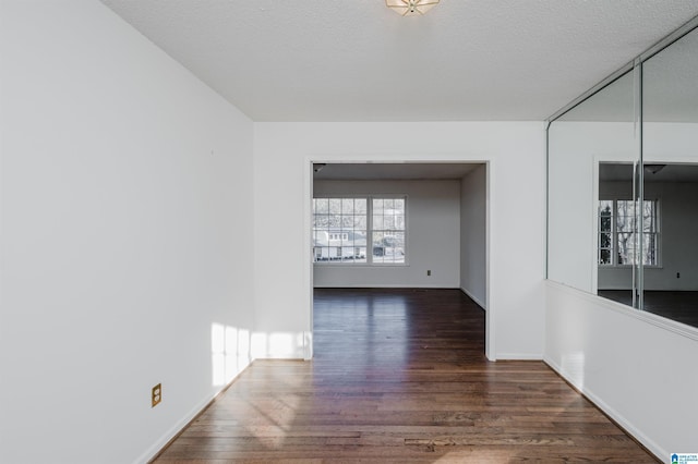 unfurnished room featuring dark hardwood / wood-style floors and a textured ceiling