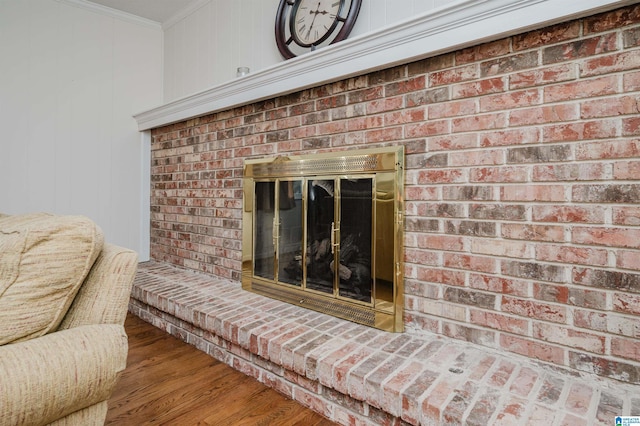 details featuring crown molding, hardwood / wood-style flooring, and a brick fireplace