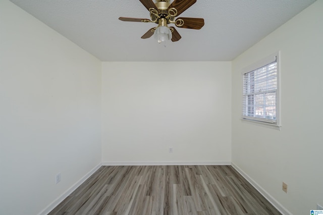 unfurnished room featuring ceiling fan, wood-type flooring, and a textured ceiling