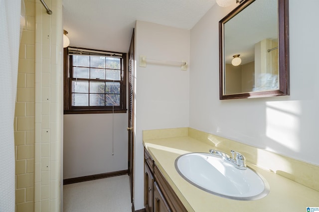 bathroom with a textured ceiling, vanity, and a shower with shower curtain