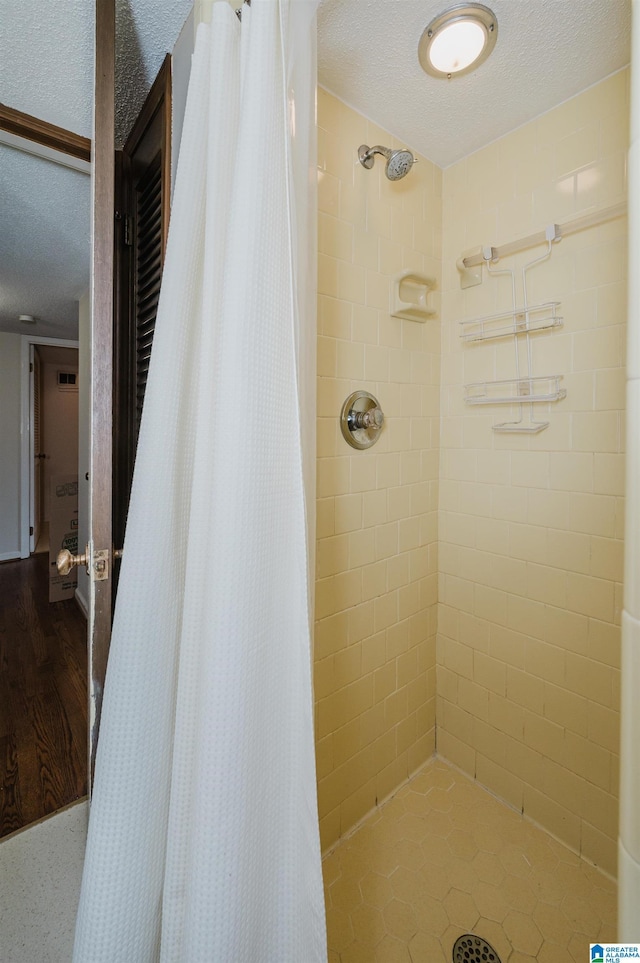 bathroom featuring a textured ceiling and a shower with shower curtain