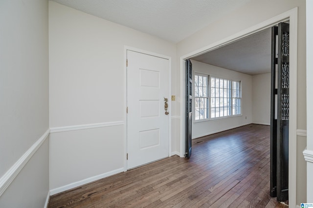 entrance foyer featuring dark wood-type flooring and a textured ceiling