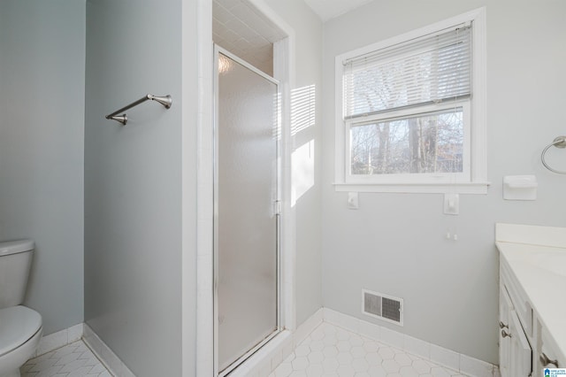 bathroom with vanity, toilet, walk in shower, and tile patterned flooring