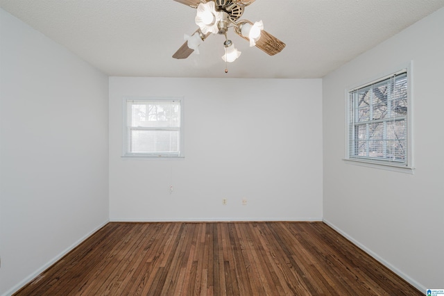 empty room with ceiling fan, dark hardwood / wood-style floors, and a textured ceiling