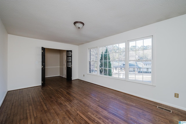 unfurnished bedroom with a textured ceiling and dark hardwood / wood-style floors