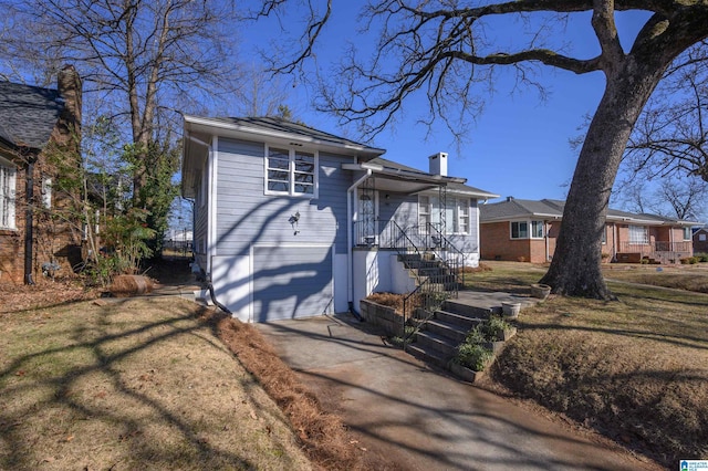 view of front of house with a garage, a front lawn, and a porch