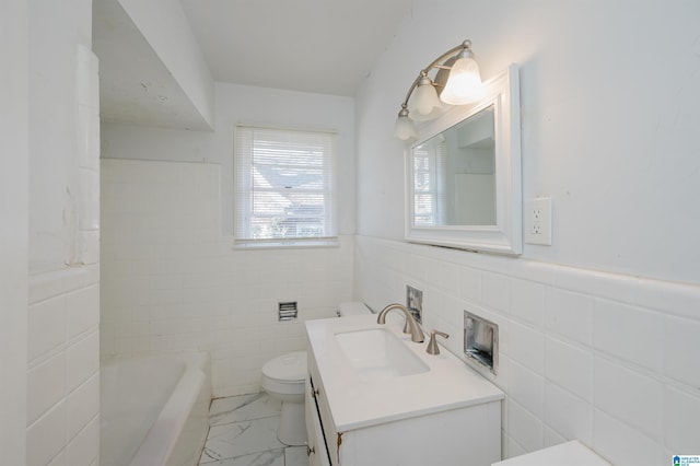 bathroom with vanity, toilet, tile walls, and a tub