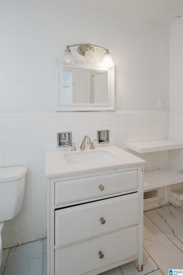 bathroom with vanity, tile walls, and toilet