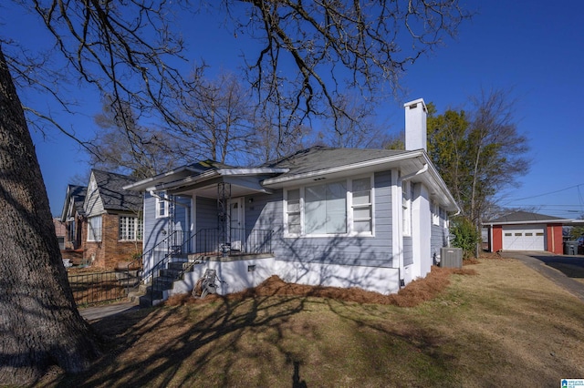 view of front facade featuring an outbuilding, a garage, central AC unit, and a front yard