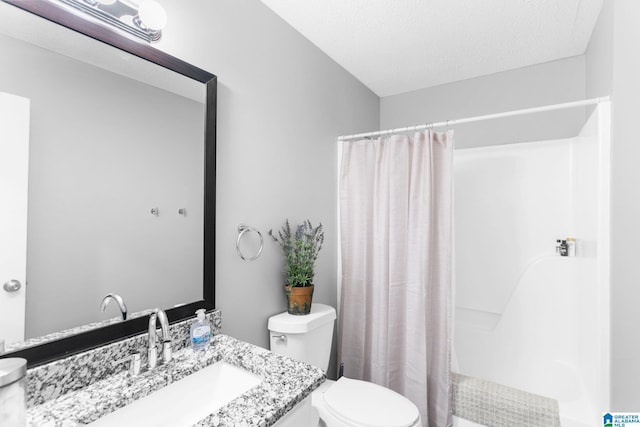 bathroom featuring vanity, toilet, and a textured ceiling