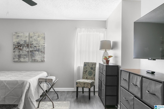 bedroom featuring wood-type flooring, a textured ceiling, and ceiling fan