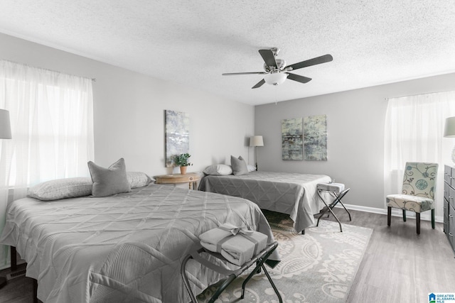 bedroom with ceiling fan, a textured ceiling, and wood-type flooring