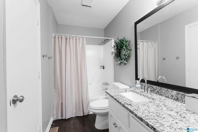 full bathroom with a textured ceiling, wood-type flooring, vanity, shower / tub combo, and toilet