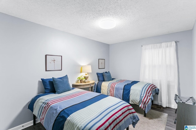 bedroom featuring dark wood-type flooring and a textured ceiling