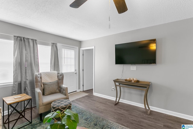 sitting room with plenty of natural light, a textured ceiling, dark hardwood / wood-style floors, and ceiling fan