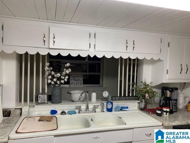 kitchen featuring sink, white cabinets, and wood ceiling