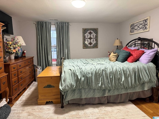 bedroom featuring light wood-style floors and visible vents