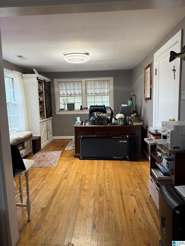 home office with light hardwood / wood-style floors