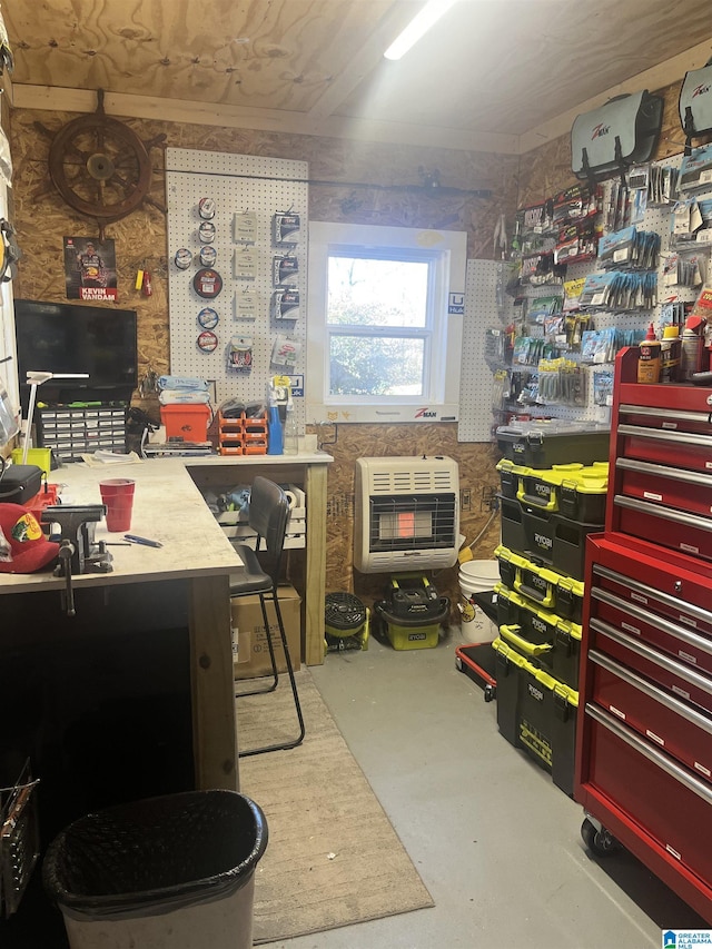 office featuring concrete flooring, heating unit, and a workshop area