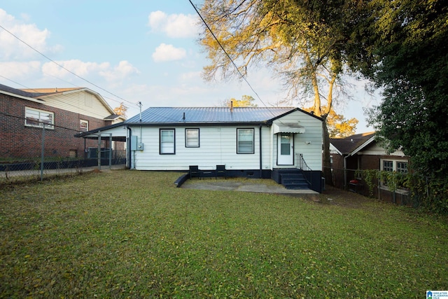 rear view of property featuring a lawn