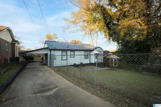 view of front of property with central AC, a front lawn, and a carport