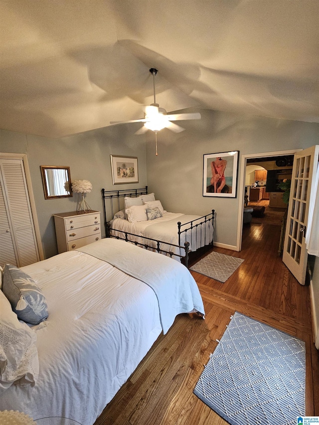 bedroom featuring lofted ceiling, dark hardwood / wood-style flooring, and ceiling fan