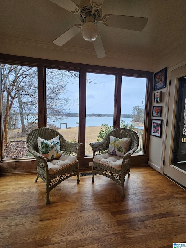 sunroom with a water view and ceiling fan