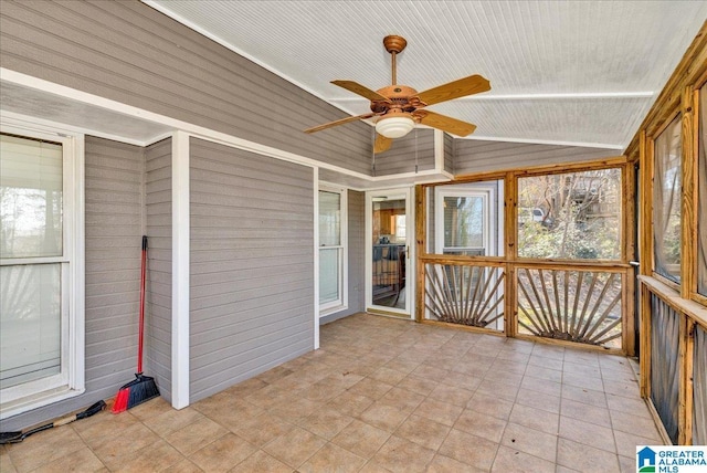 unfurnished sunroom featuring ceiling fan and vaulted ceiling