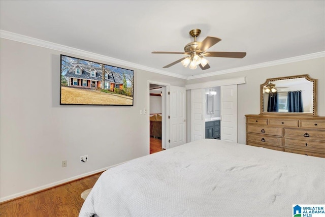 bedroom featuring ceiling fan, ensuite bathroom, crown molding, and hardwood / wood-style floors