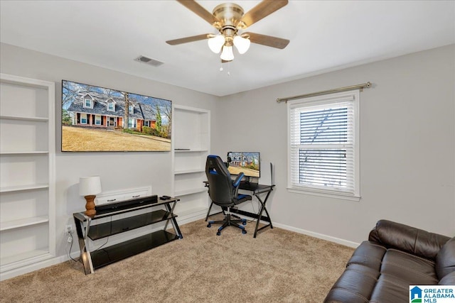 home office with light carpet, ceiling fan, and built in features