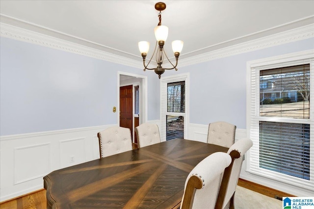 dining room with crown molding, a chandelier, and hardwood / wood-style flooring