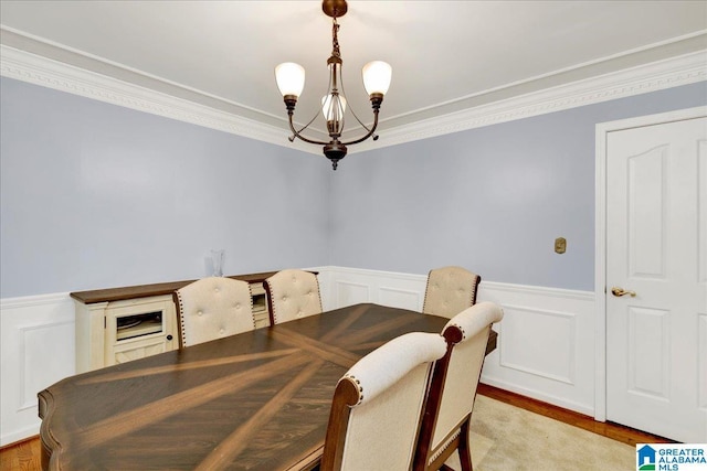 dining space with light hardwood / wood-style flooring, a chandelier, and ornamental molding