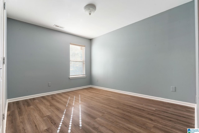 spare room featuring dark wood-type flooring