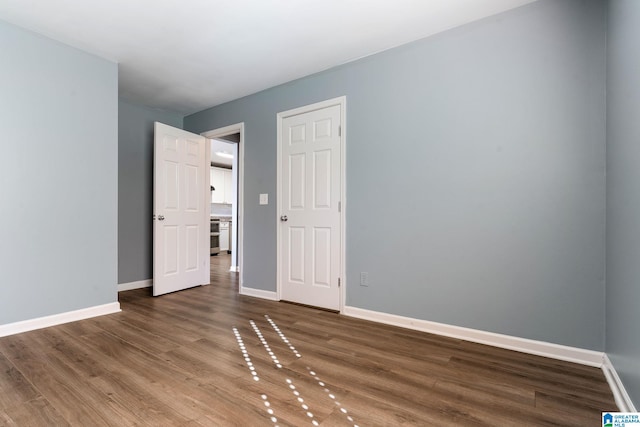 unfurnished bedroom with dark hardwood / wood-style floors