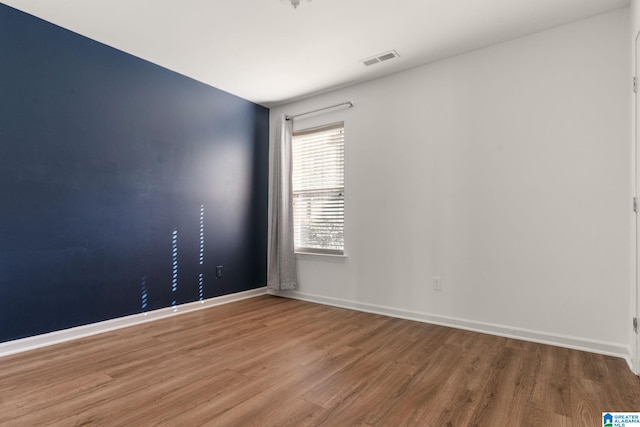 unfurnished room with hardwood / wood-style floors