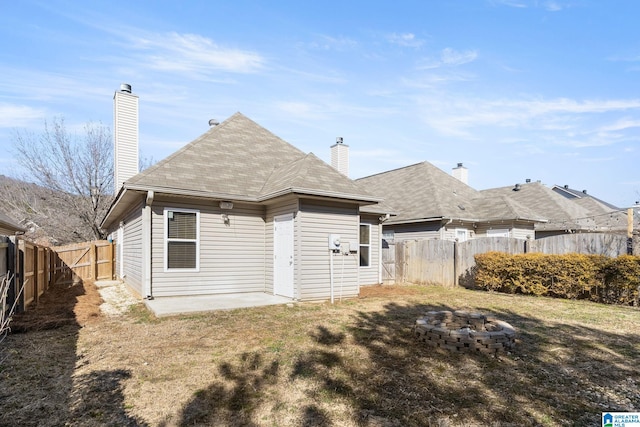 back of property featuring a lawn, a patio, and a fire pit