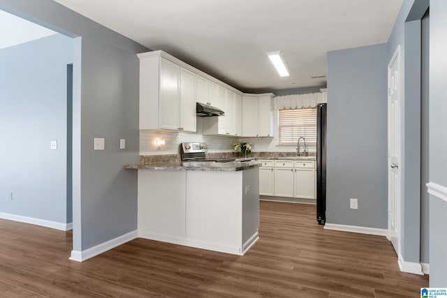 kitchen with backsplash, dark hardwood / wood-style floors, electric range, sink, and white cabinetry