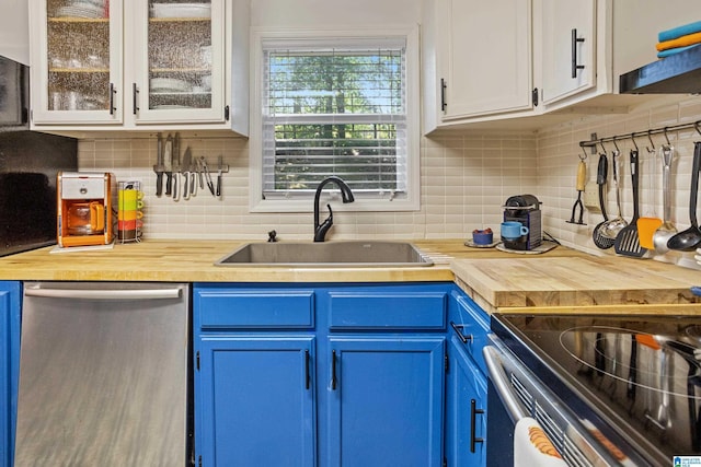 kitchen featuring white cabinetry, stainless steel dishwasher, blue cabinets, and sink