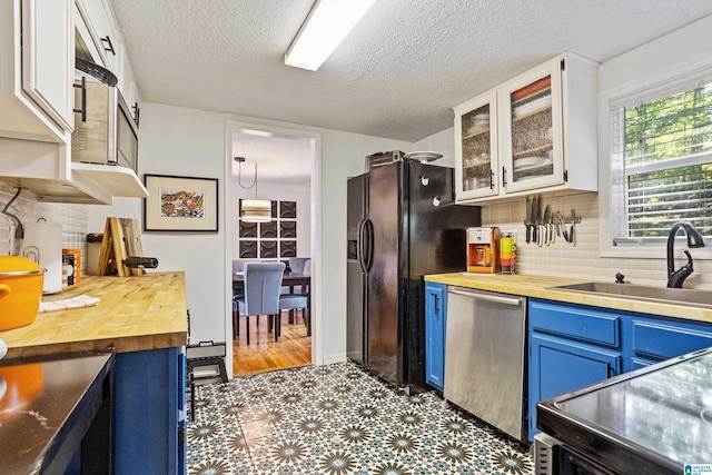 kitchen featuring white cabinets, dishwasher, sink, and blue cabinetry