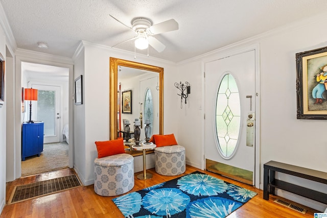 foyer entrance with hardwood / wood-style floors, a textured ceiling, and a healthy amount of sunlight