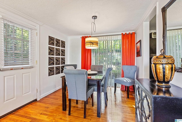 dining area with a textured ceiling, ornamental molding, and hardwood / wood-style floors