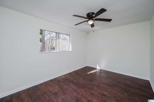 empty room featuring ceiling fan, dark hardwood / wood-style floors, and a textured ceiling