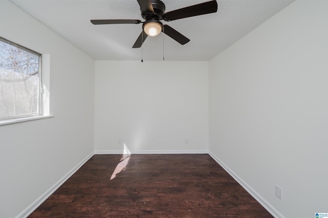spare room featuring dark hardwood / wood-style floors and a textured ceiling
