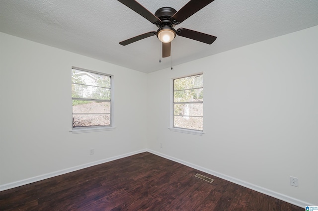 spare room featuring dark hardwood / wood-style flooring and a textured ceiling